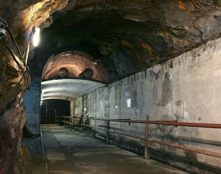 Betonowy korytarz kompleksu Rzeczka ze sklepieniem i poręczą wzdłuż ściany